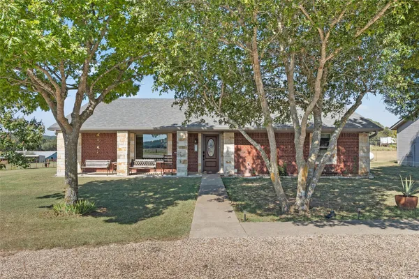 a front view of a house with a yard and trees