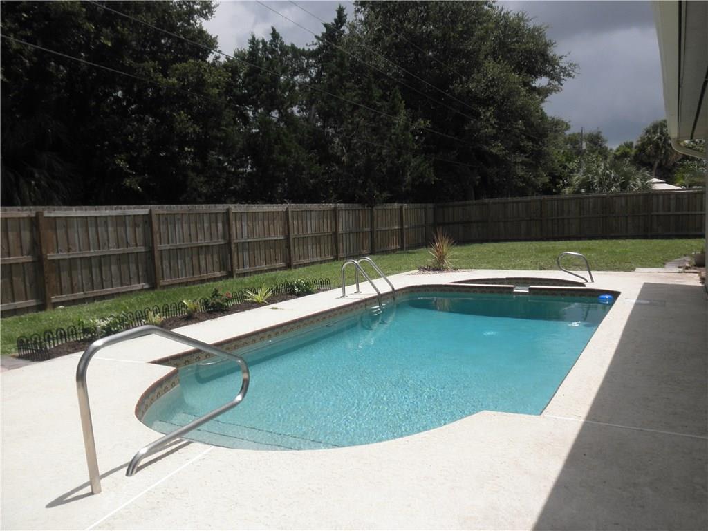 540 South Manor Drive Stuart, FL 34994 - Photo 3 of 22 a view of a swimming pool with a yard and wooden fence
