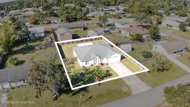 an aerial view of a house with a yard