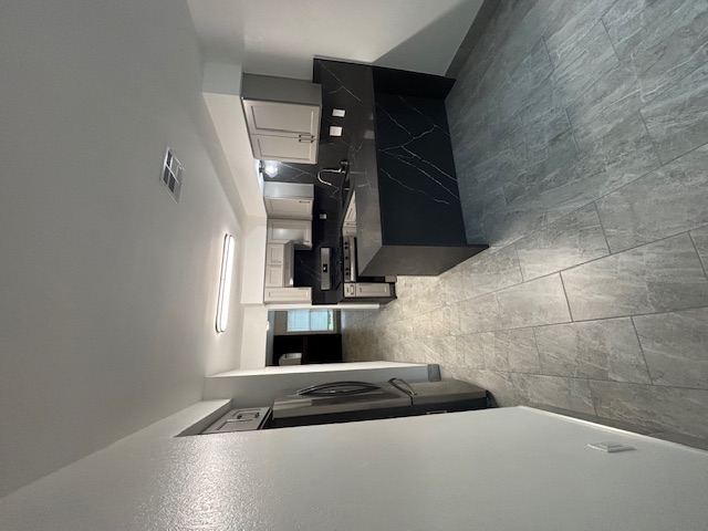 11801 Argonne Forest Trail, Unit B Austin, TX 78759 - Photo 10 of 12 a kitchen with stainless steel appliances granite countertop a refrigerator and a sink