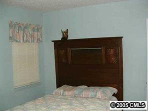 6219 Old Meadow Road Charlotte, NC 28227 - Photo 7 of 8 a bedroom with a bed and a wall painting