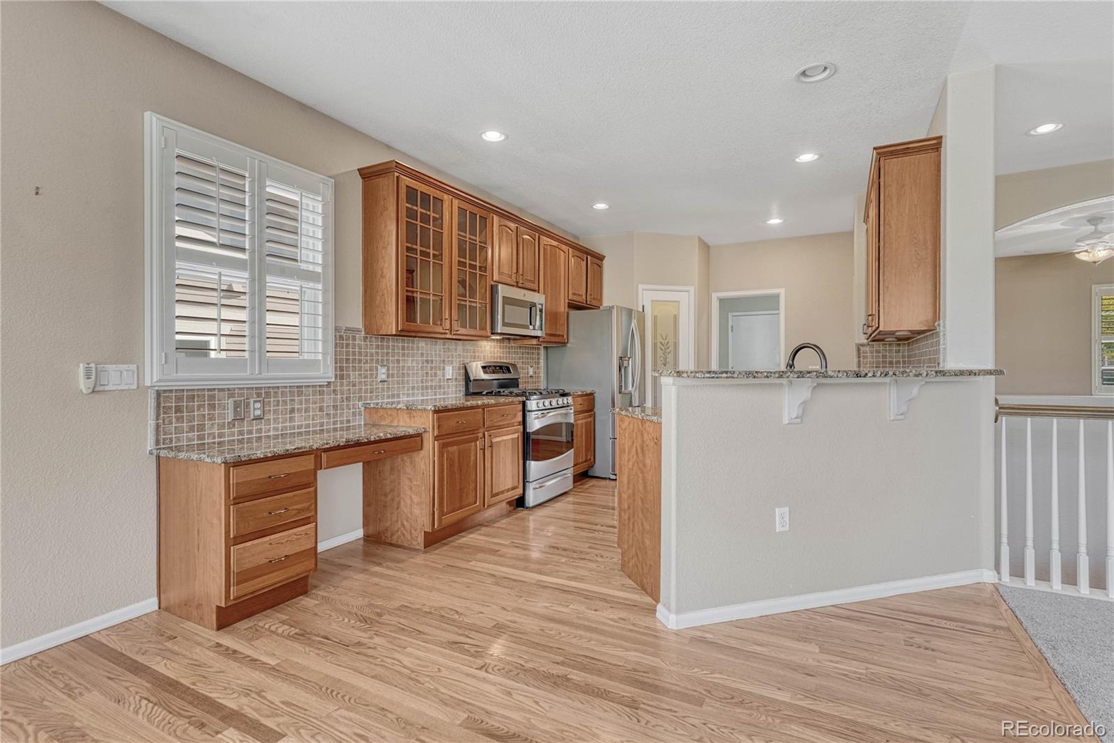 8107 South Catawba Court Aurora, CO 80016 - Photo 12 of 46 a kitchen with stainless steel appliances granite countertop a stove a sink and a refrigerator
