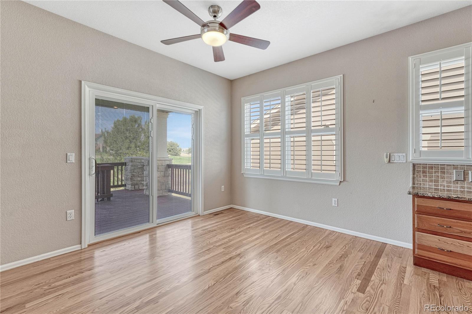 8107 South Catawba Court Aurora, CO 80016 - Photo 17 of 46 an empty room with wooden floor fan and windows