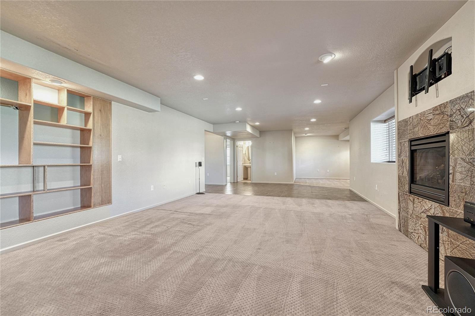 8107 South Catawba Court Aurora, CO 80016 - Photo 28 of 46 a view of an empty room with a fireplace and a window