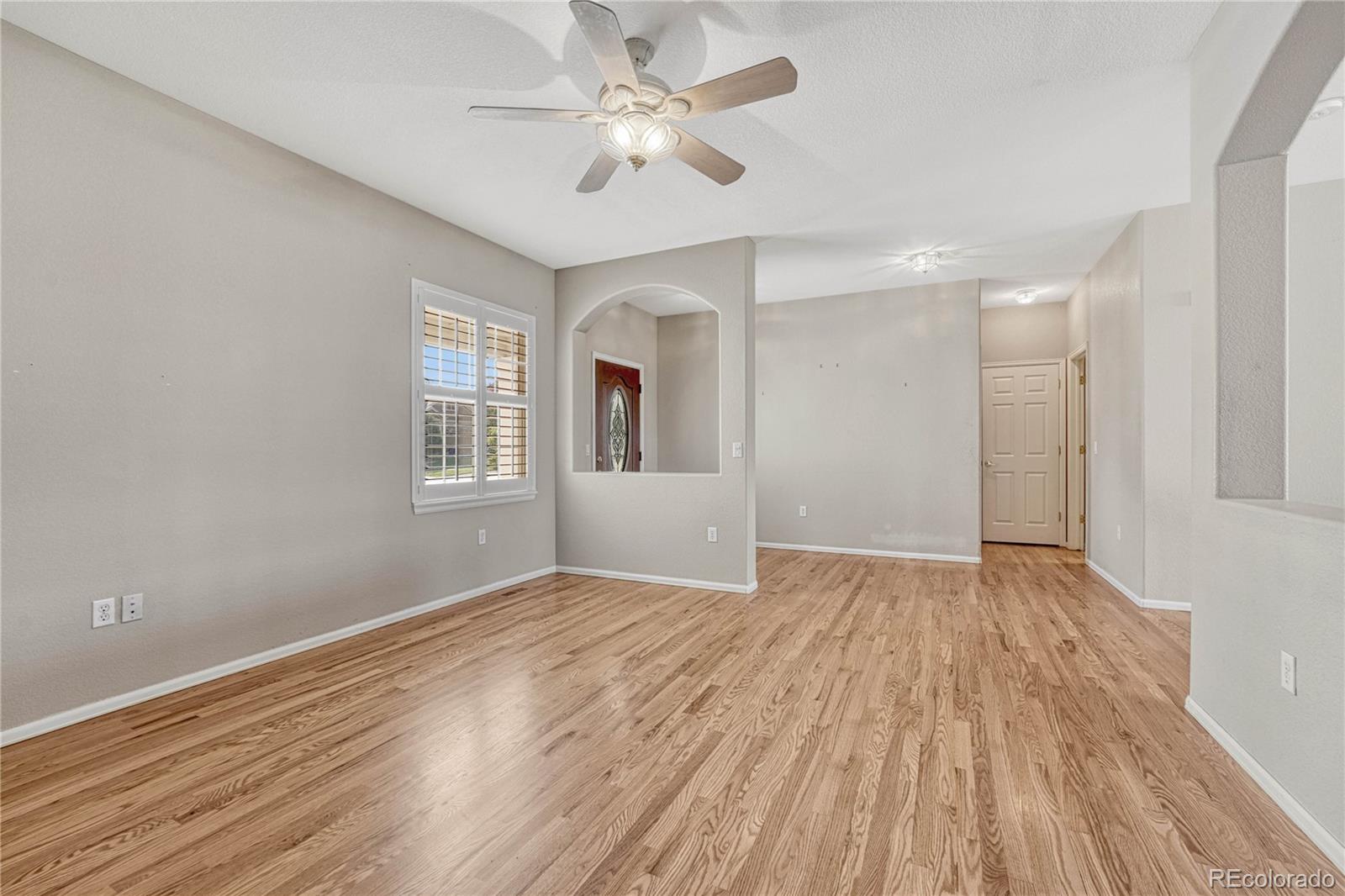 8107 South Catawba Court Aurora, CO 80016 - Photo 6 of 46 wooden floor in an empty room with a window