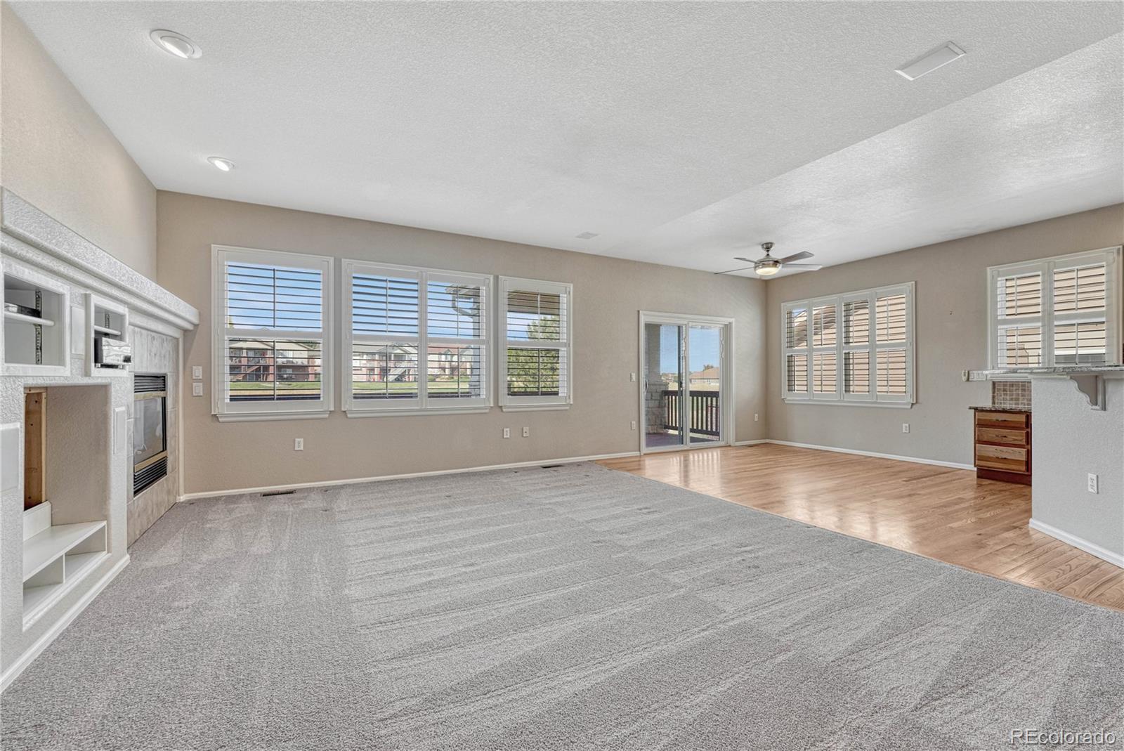 8107 South Catawba Court Aurora, CO 80016 - Photo 9 of 46 a view of an empty room with a window and wooden floor
