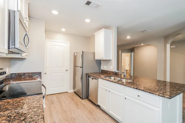a kitchen with stainless steel appliances granite countertop a sink and cabinets