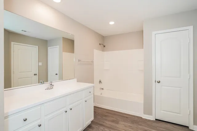 a bathroom with a shower sink and mirror