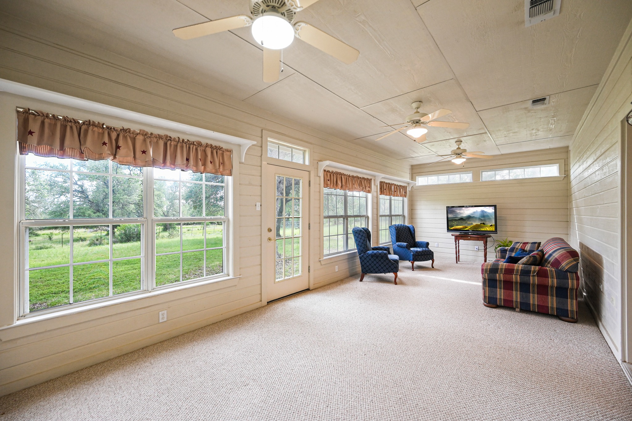 364 Nameless Road Driftwood, TX 78619 - Photo 19 of 32 A tranquil sunroom provides abundant natural light and seamless outdoor connectivity.