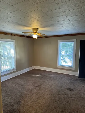 a view of a room with wooden floor and windows