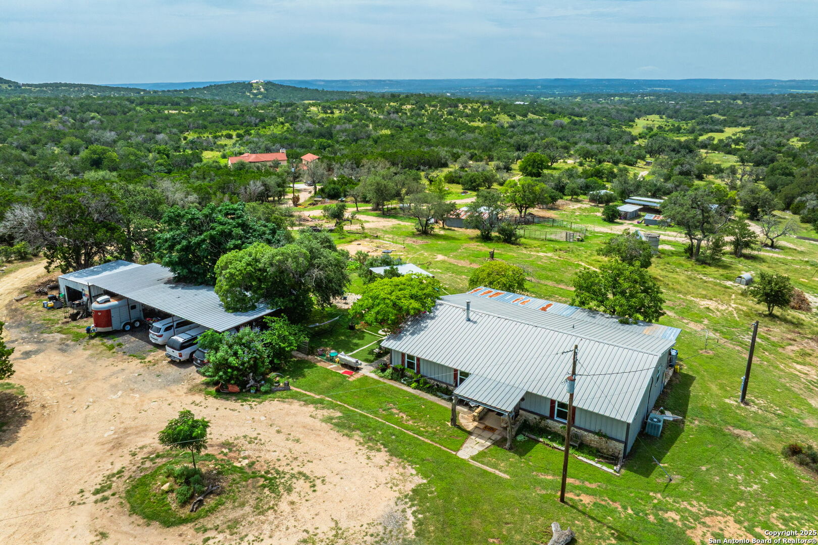 943 Stoneleigh Road Center Point, TX 78010 - Photo 2 of 36 an aerial view of a house with a garden and lake view