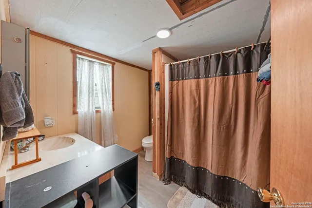 a bathroom with a sink a mirror and a shower curtain