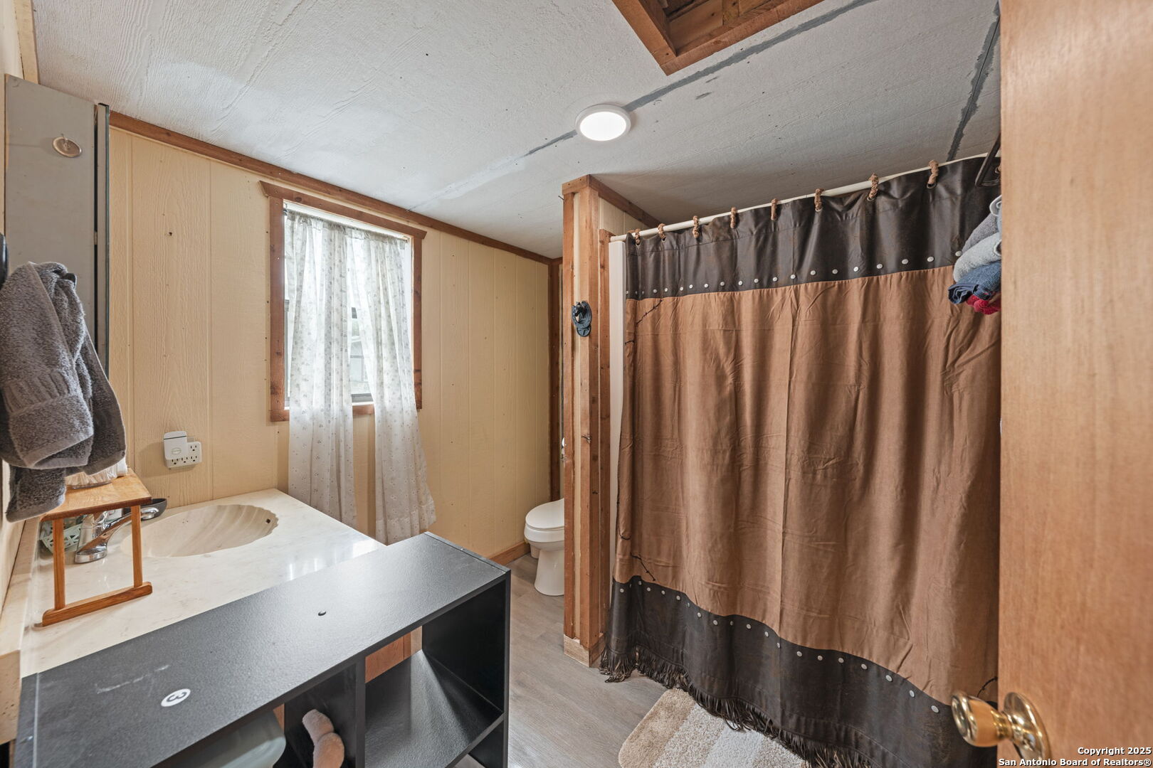 943 Stoneleigh Road Center Point, TX 78010 - Photo 21 of 36 a bathroom with a sink a mirror and a shower curtain