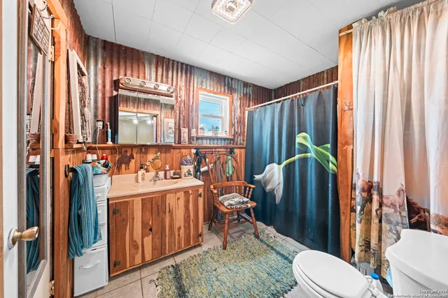 a bathroom with a toilet a sink and mirror