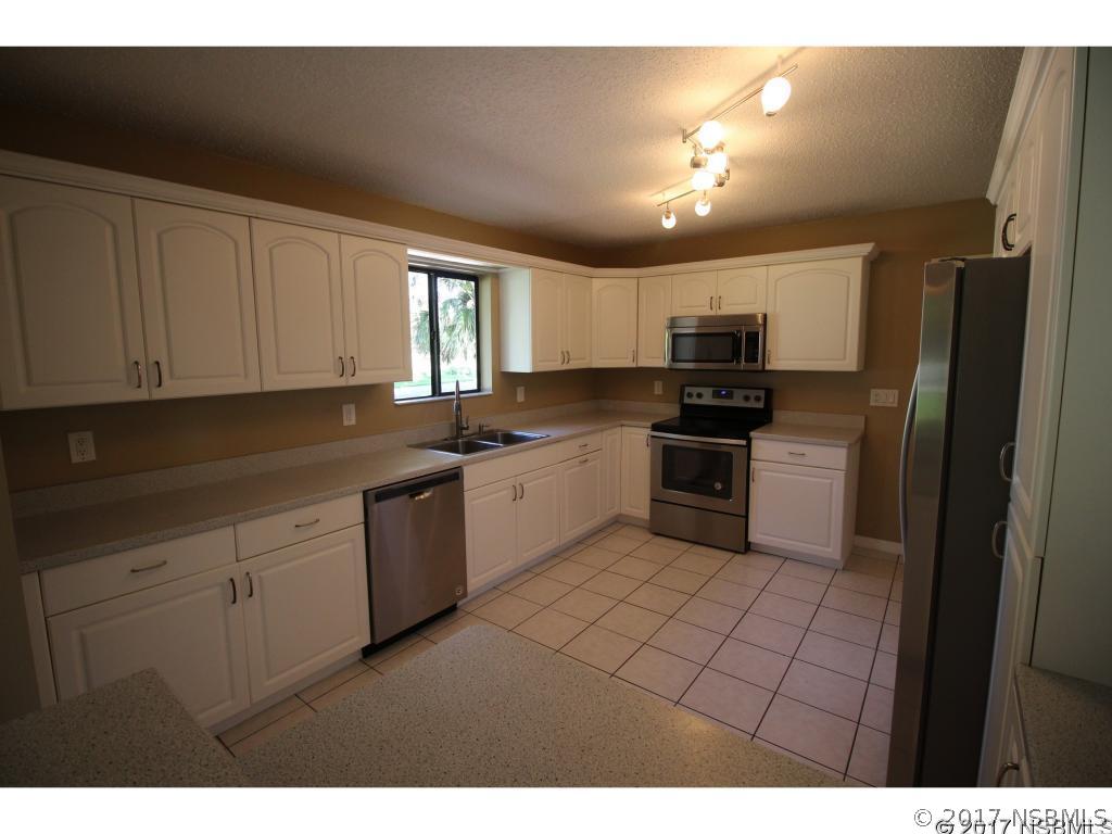 2007 Orange Tree Drive Edgewater, FL 32141 - Photo 7 of 23 a kitchen with granite countertop a refrigerator sink and cabinets