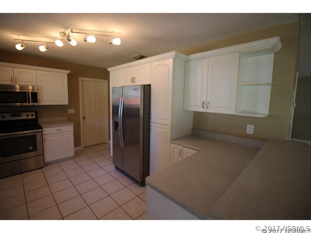 2007 Orange Tree Drive Edgewater, FL 32141 - Photo 8 of 23 a kitchen with refrigerator and cabinets