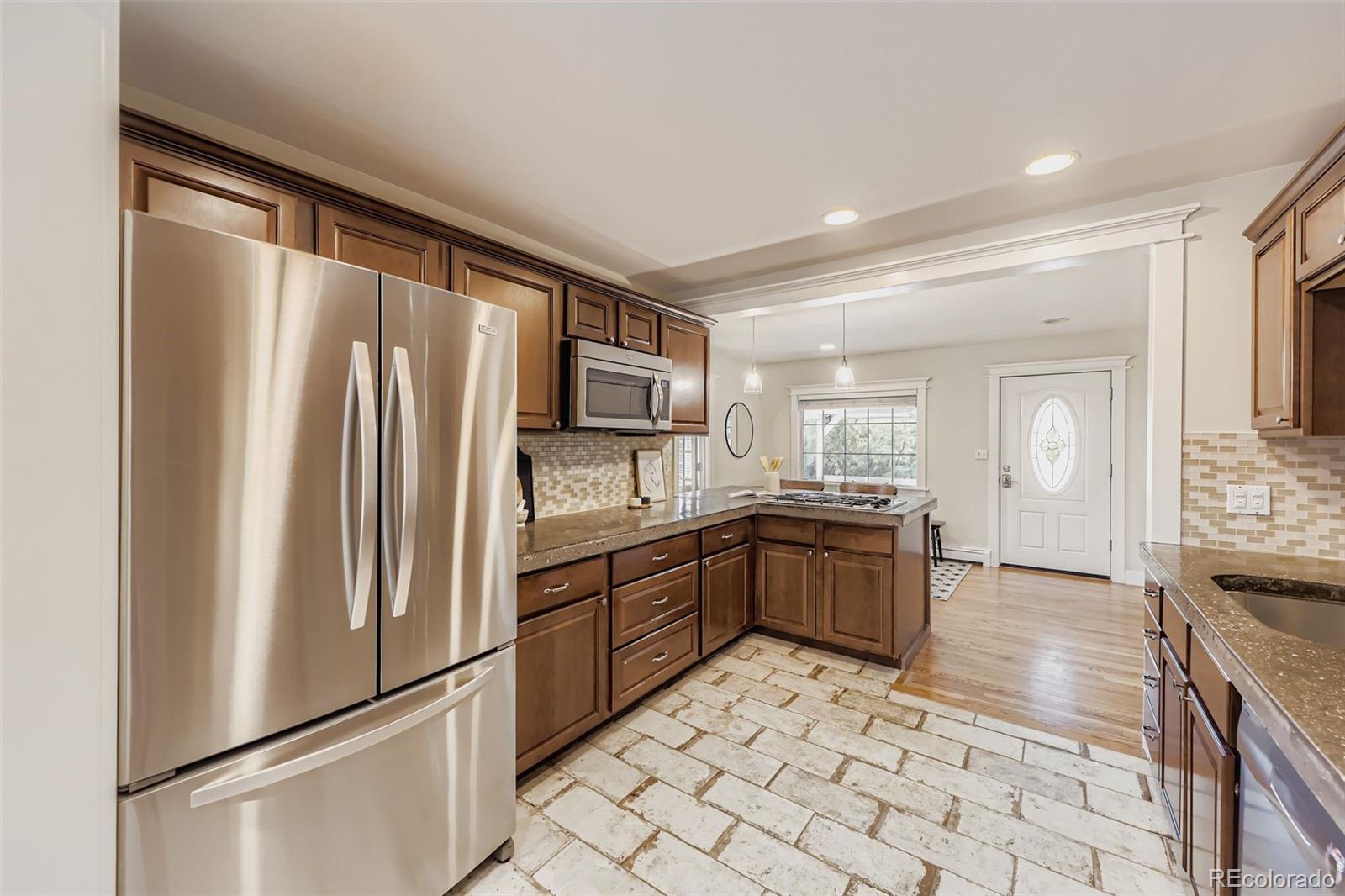 120 Gilbert Street Castle Rock, CO 80104 - Photo 11 of 25 a kitchen with granite countertop a refrigerator and a sink