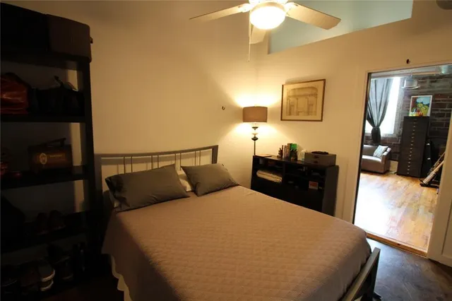 a bedroom with a bed and wooden floor