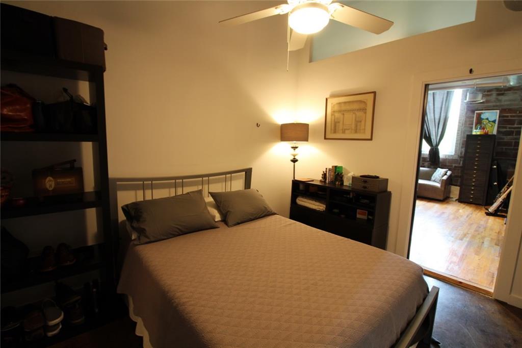 172 Haynes Street Southwest, Unit 208 Atlanta, GA 30313 - Photo 21 of 30 a bedroom with a bed and wooden floor