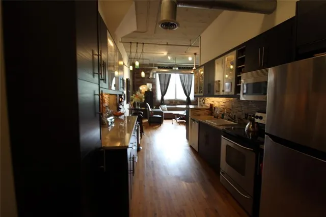 a kitchen with granite countertop a refrigerator a sink a stove and a refrigerator