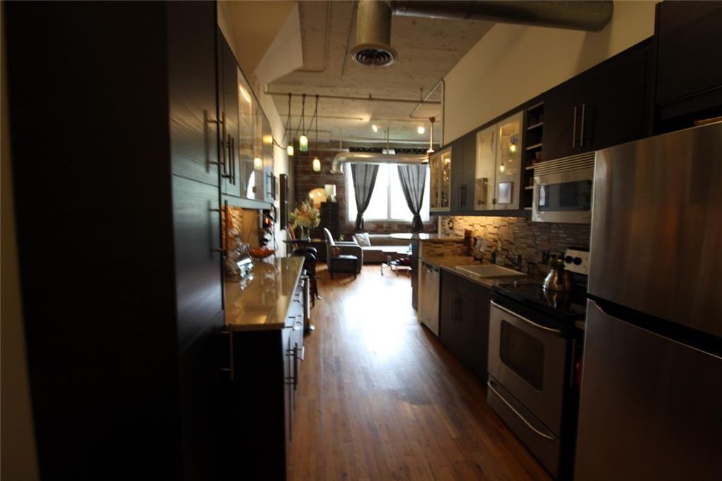 172 Haynes Street Southwest, Unit 208 Atlanta, GA 30313 - Photo 7 of 30 a kitchen with granite countertop a refrigerator a sink a stove and a refrigerator