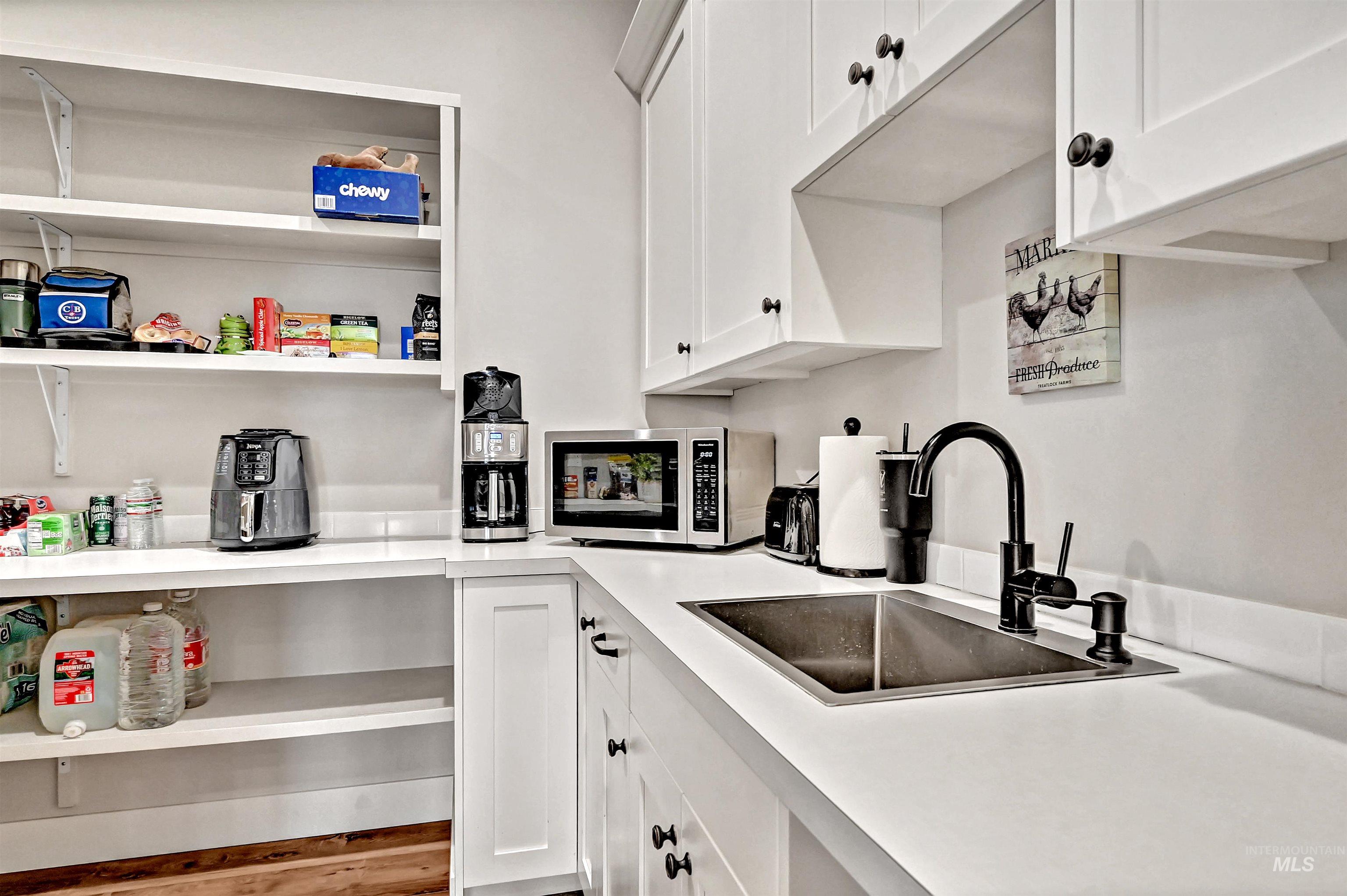 14964 Mortensen Court Caldwell, ID 83607 - Photo 14 of 38 Kitchen with white cabinets, light countertops, and stainless steel microwave