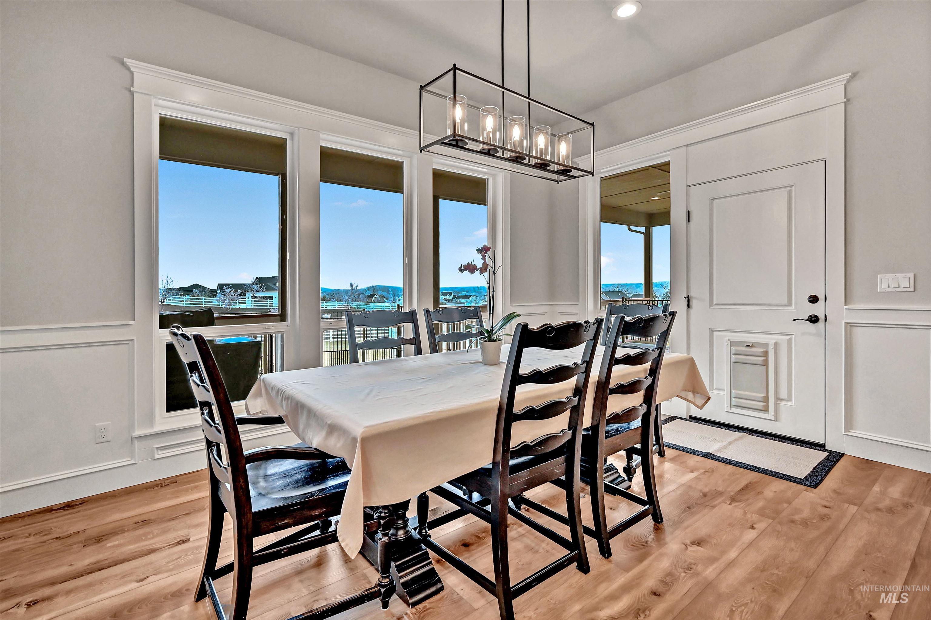 14964 Mortensen Court Caldwell, ID 83607 - Photo 15 of 38 Dining area with a decorative wall, plenty of natural light, light wood-style flooring, and wainscoting