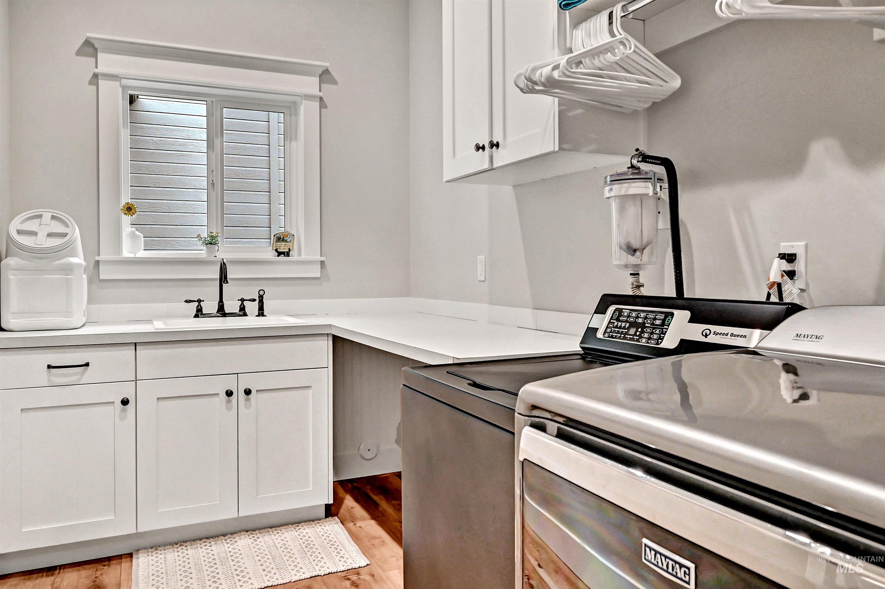14964 Mortensen Court Caldwell, ID 83607 - Photo 16 of 38 Laundry room with cabinet space, washing machine and dryer, and light wood-type flooring