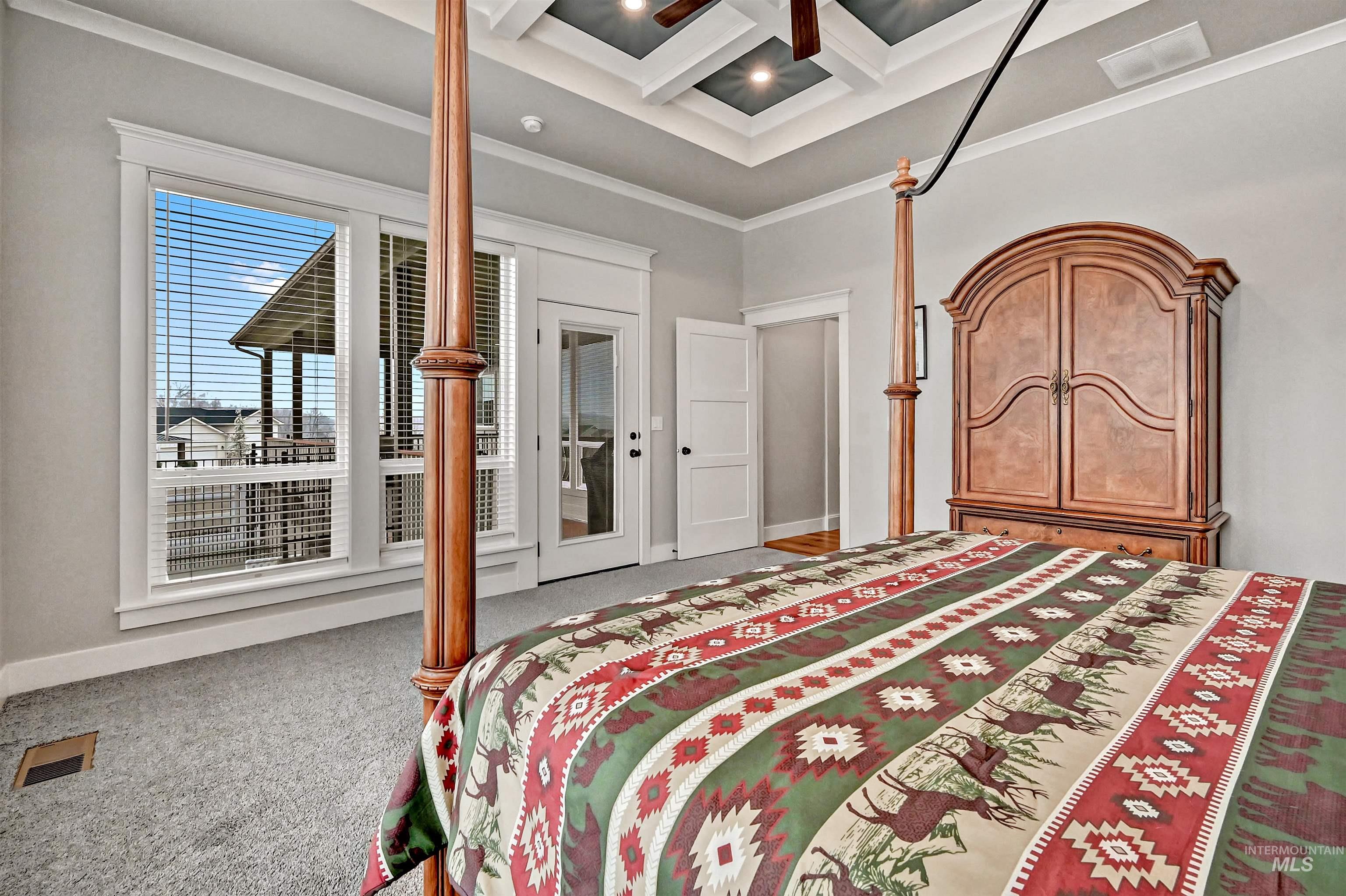 14964 Mortensen Court Caldwell, ID 83607 - Photo 21 of 38 Bedroom featuring coffered ceiling, beam ceiling, ornamental molding, access to exterior, and carpet