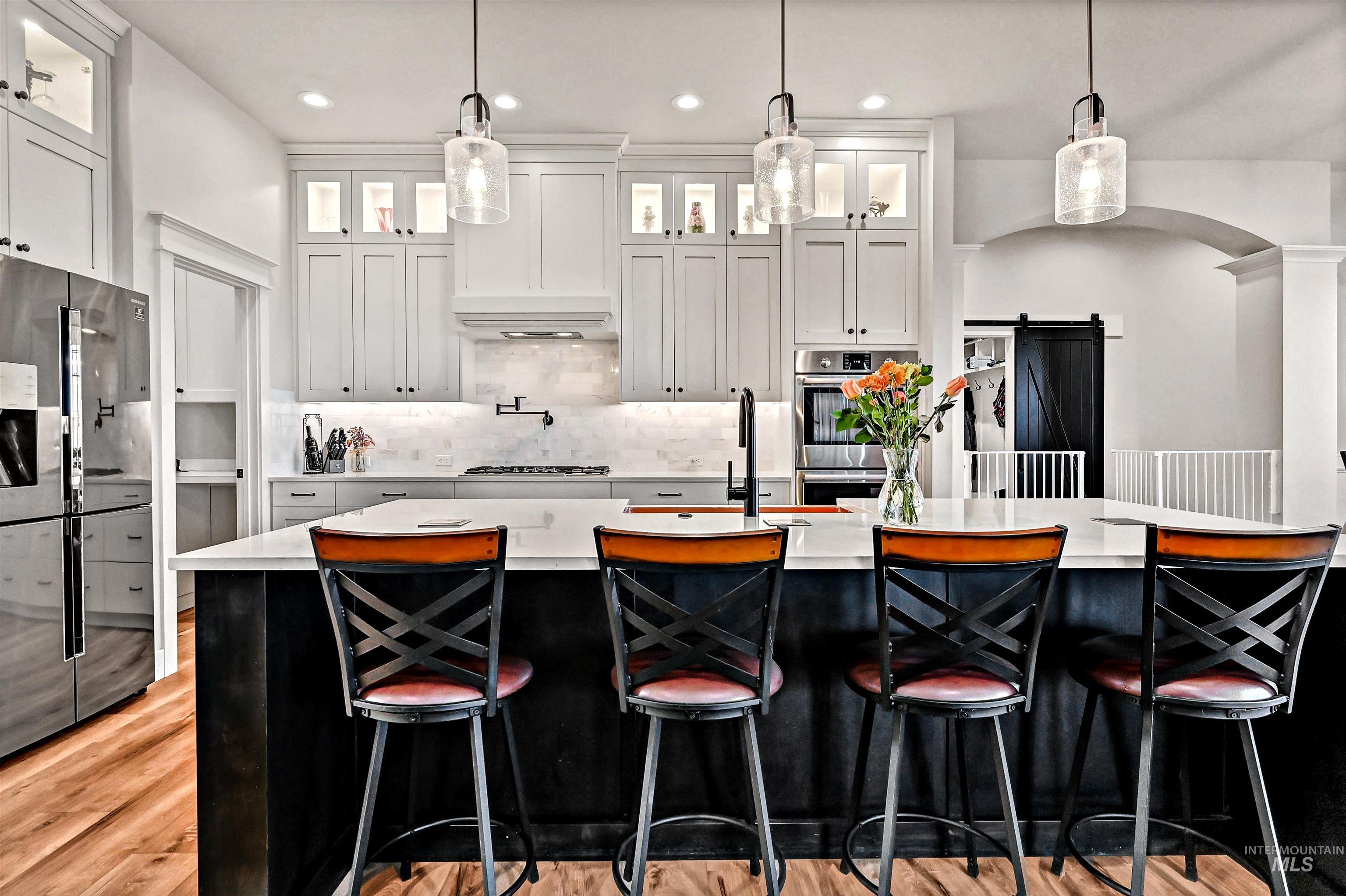 14964 Mortensen Court Caldwell, ID 83607 - Photo 5 of 38 Kitchen with a barn door, dark cabinets, pendant lighting, stainless steel appliances, and recessed lighting