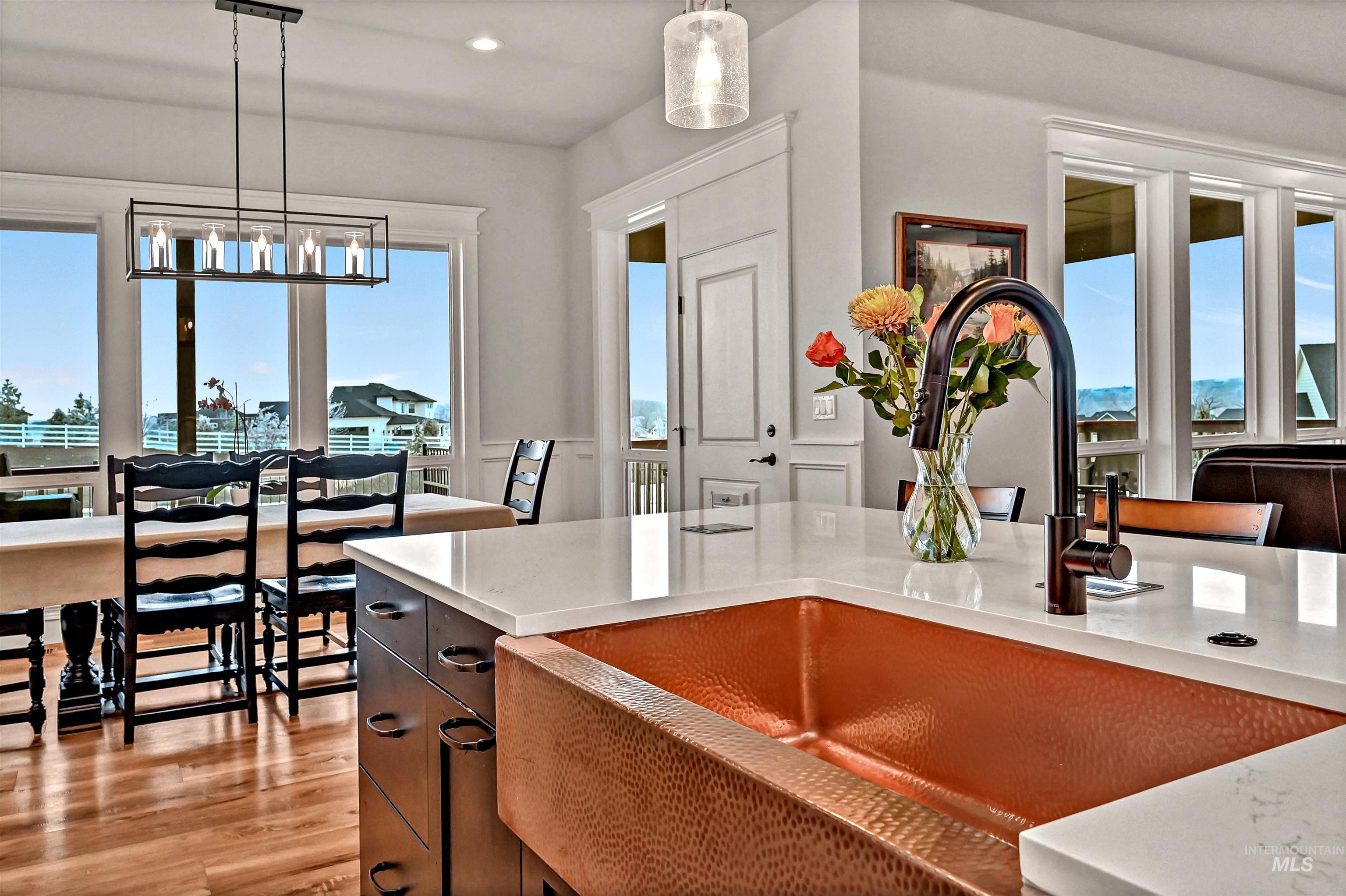 14964 Mortensen Court Caldwell, ID 83607 - Photo 6 of 38 Kitchen featuring plenty of natural light, pendant lighting, light wood-style flooring, dark cabinets, and recessed lighting