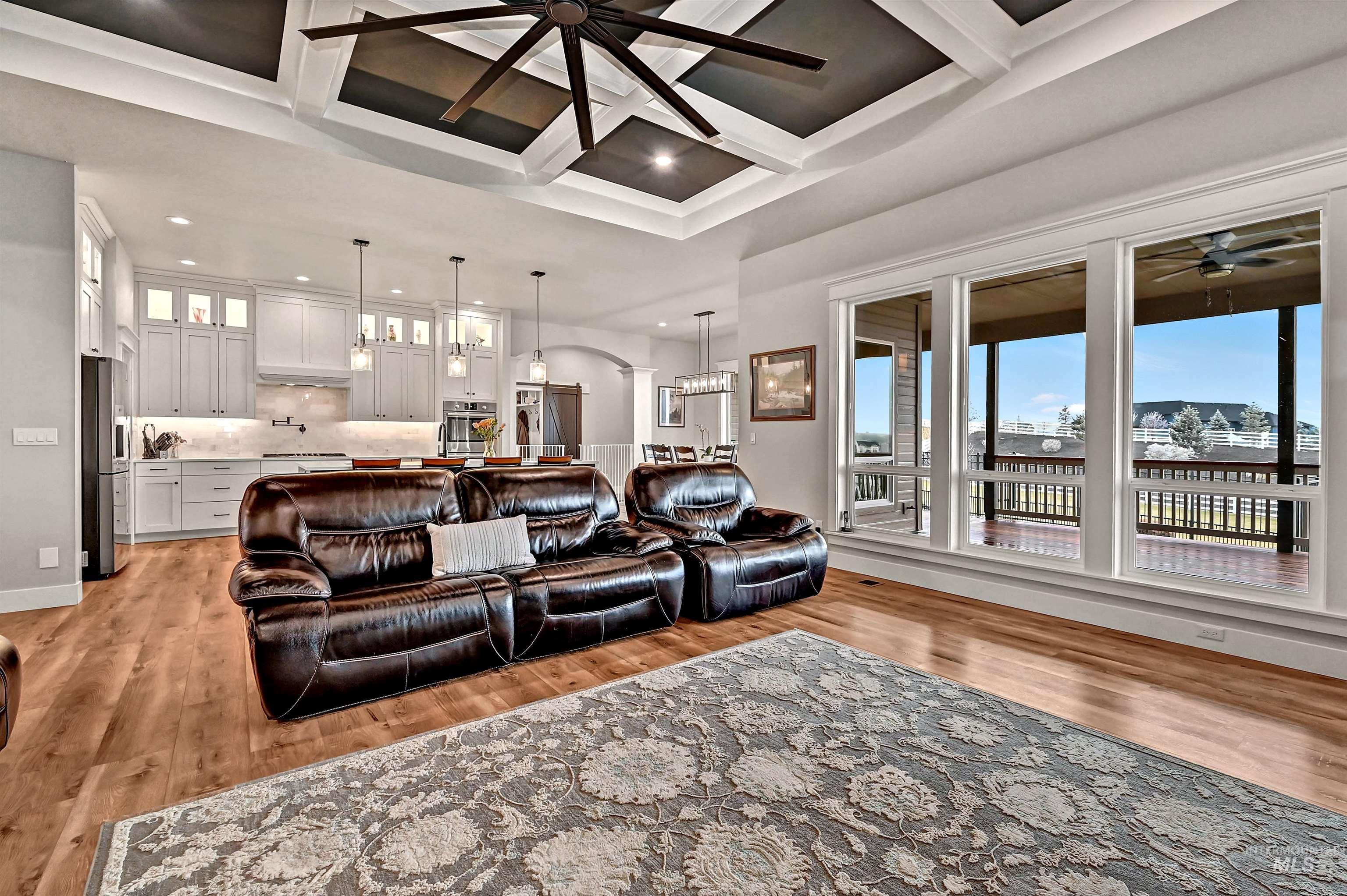 14964 Mortensen Court Caldwell, ID 83607 - Photo 7 of 38 Living room with healthy amount of natural light, coffered ceiling, a ceiling fan, light wood-style flooring, and beamed ceiling