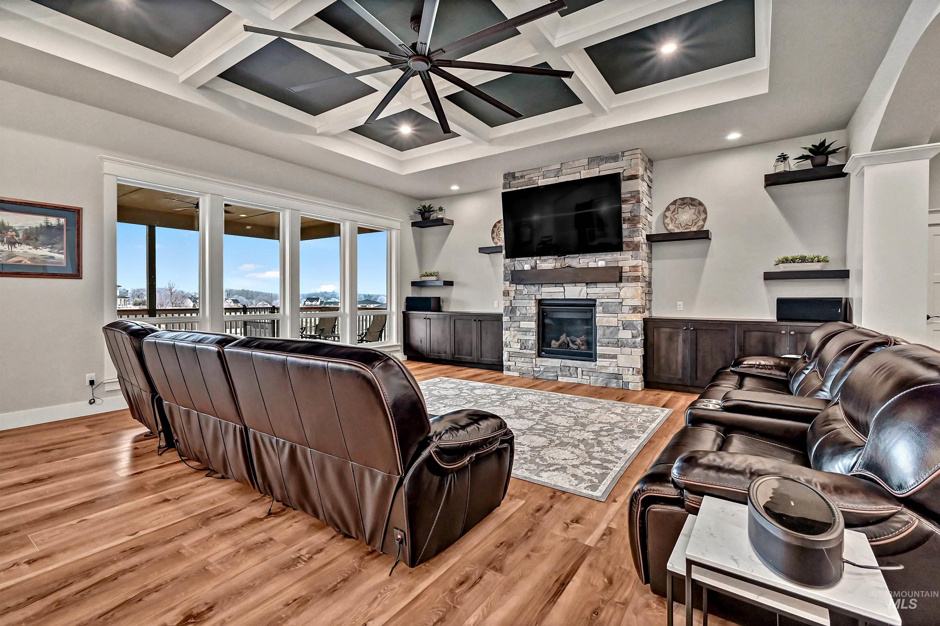 14964 Mortensen Court Caldwell, ID 83607 - Photo 10 of 38 Living room featuring coffered ceiling, a stone fireplace, light wood finished floors, beam ceiling, and ceiling fan
