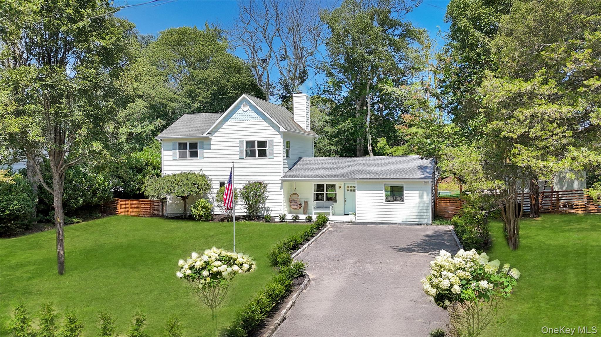 9 Pine Tree Road Southampton, NY 11968 - Photo 1 of 20 a front view of a house with a garden and trees
