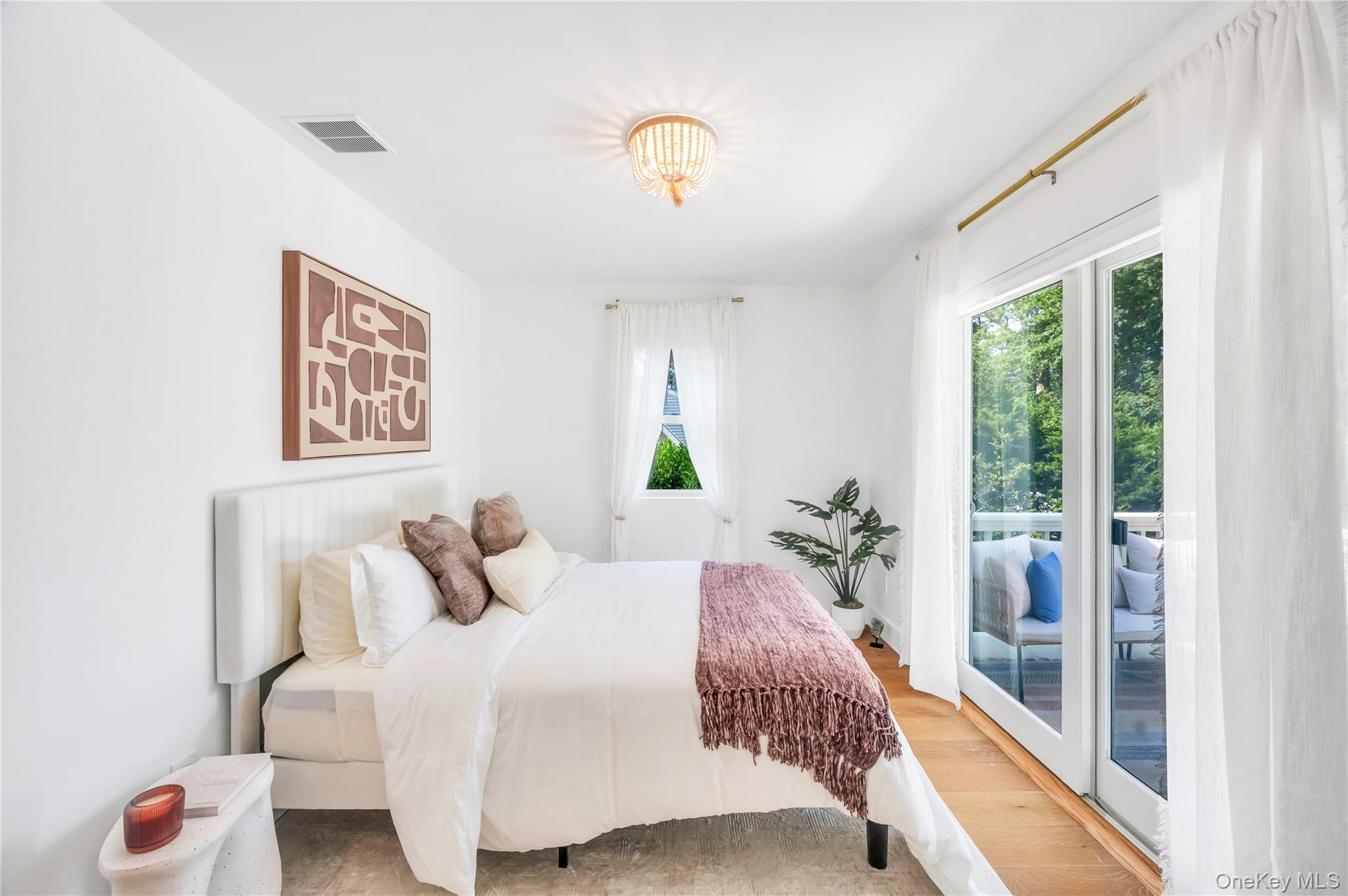 9 Pine Tree Road Southampton, NY 11968 - Photo 14 of 20 a bedroom with a large bed and a chandelier