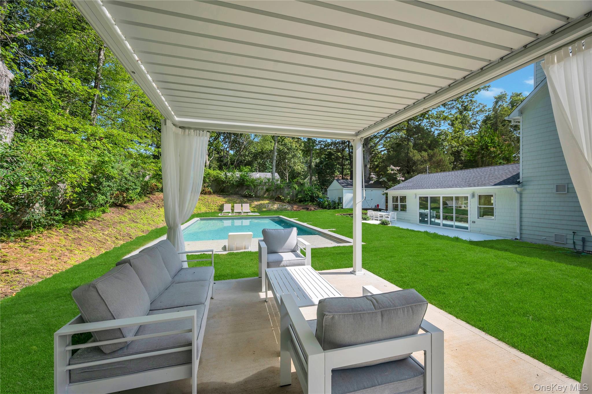 9 Pine Tree Road Southampton, NY 11968 - Photo 17 of 20 a view of a patio with couches chairs and backyard