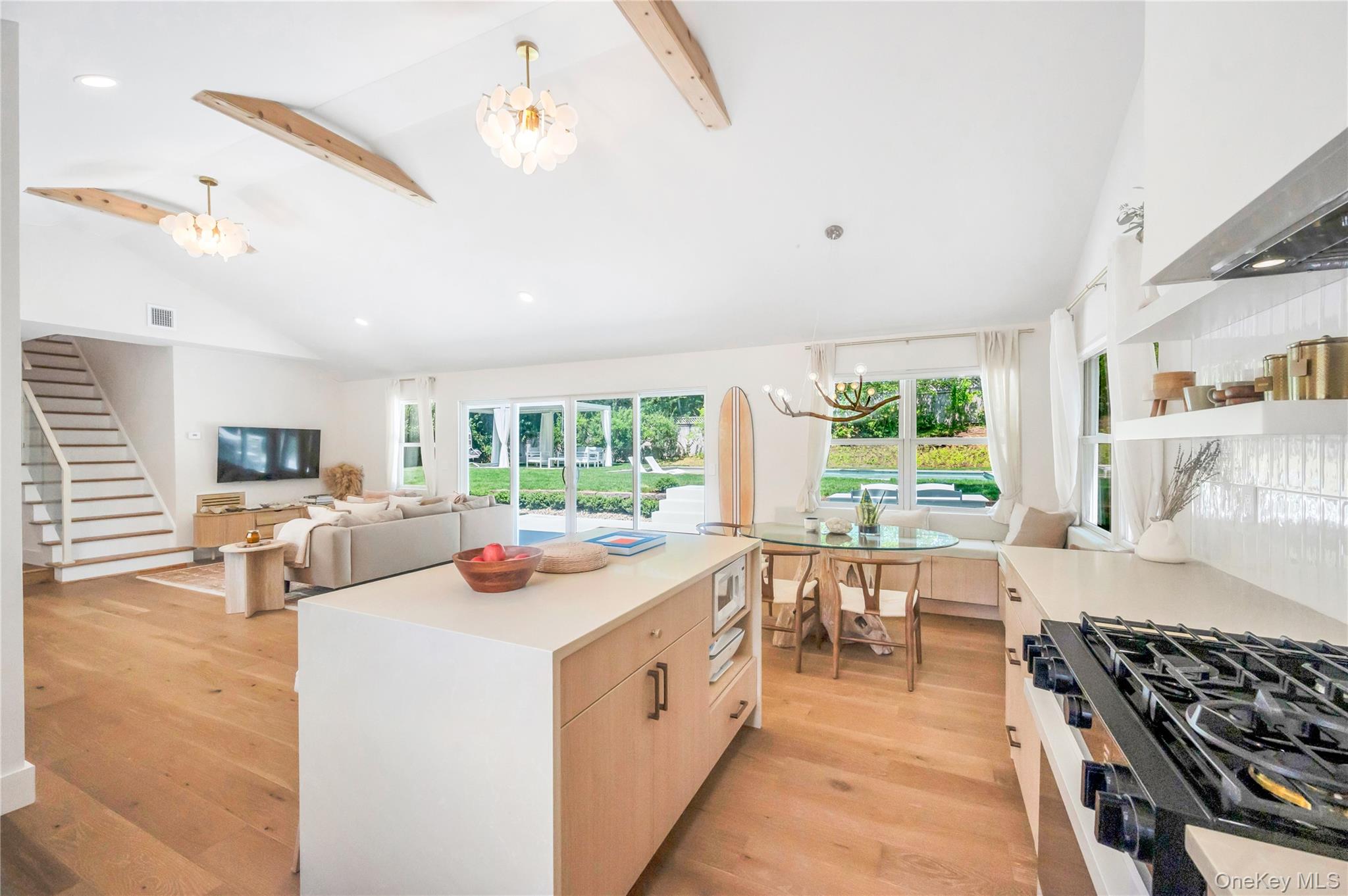 9 Pine Tree Road Southampton, NY 11968 - Photo 20 of 20 a kitchen with stainless steel appliances a stove a sink a oven a dining table and chairs with wooden floor