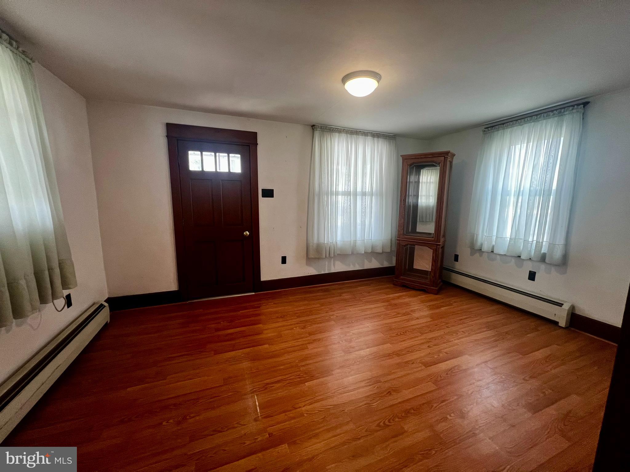 128 Main Street Lykens, PA 17048 - Photo 14 of 28 an empty room with wooden floor and windows