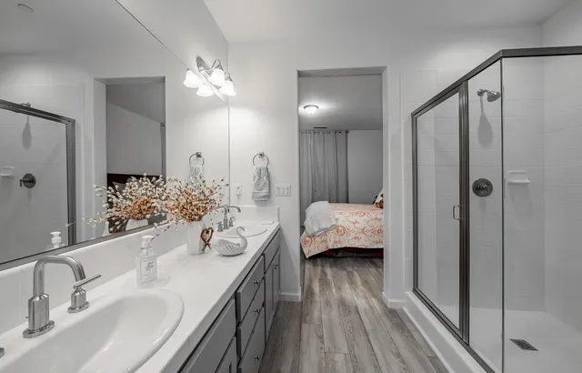 a en suite spacious bathroom with a double vanity sink a mirror and shower