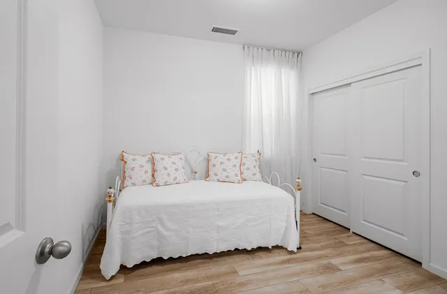 a bedroom with a bed and wooden floor