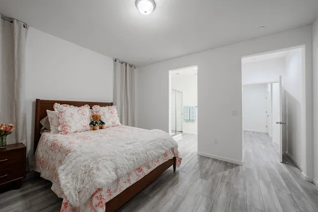 a bedroom with a bed and wooden floor