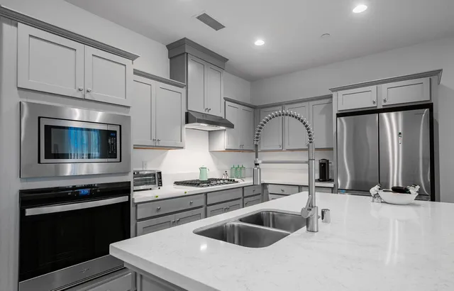 a kitchen with granite countertop a sink a stove and cabinets