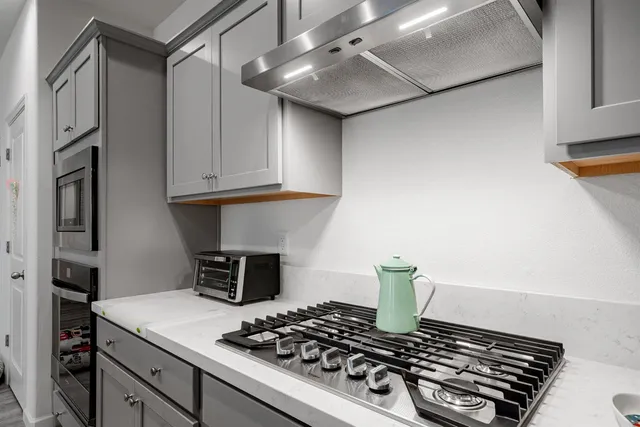 a stove top oven sitting inside of a kitchen