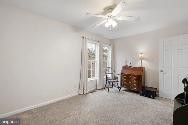 a view of a bedroom with furniture and a ceiling fan