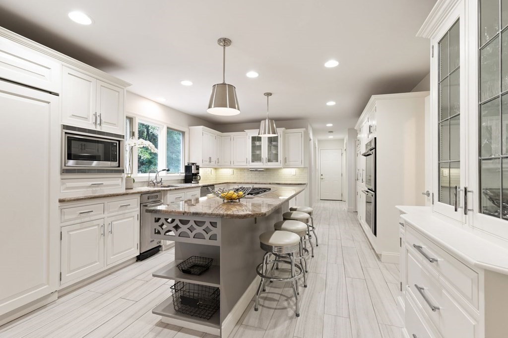 30 Castle Drive Sharon, MA 02067 - Photo 21 of 42 a large kitchen with stainless steel appliances kitchen island granite countertop a lot of counter space and a wooden floors