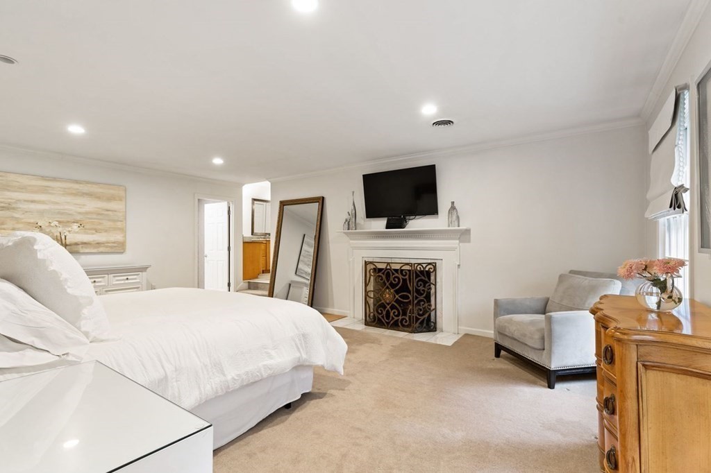 30 Castle Drive Sharon, MA 02067 - Photo 30 of 42 a spacious bedroom with a bed a couch and a flat screen tv