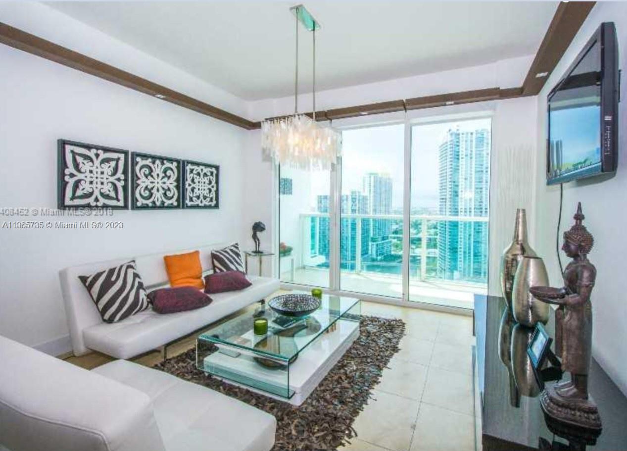31 Southeast 5th Street, Unit 3309 Miami, FL 33131 - Photo 2 of 15 a living room with furniture and a flat screen tv
