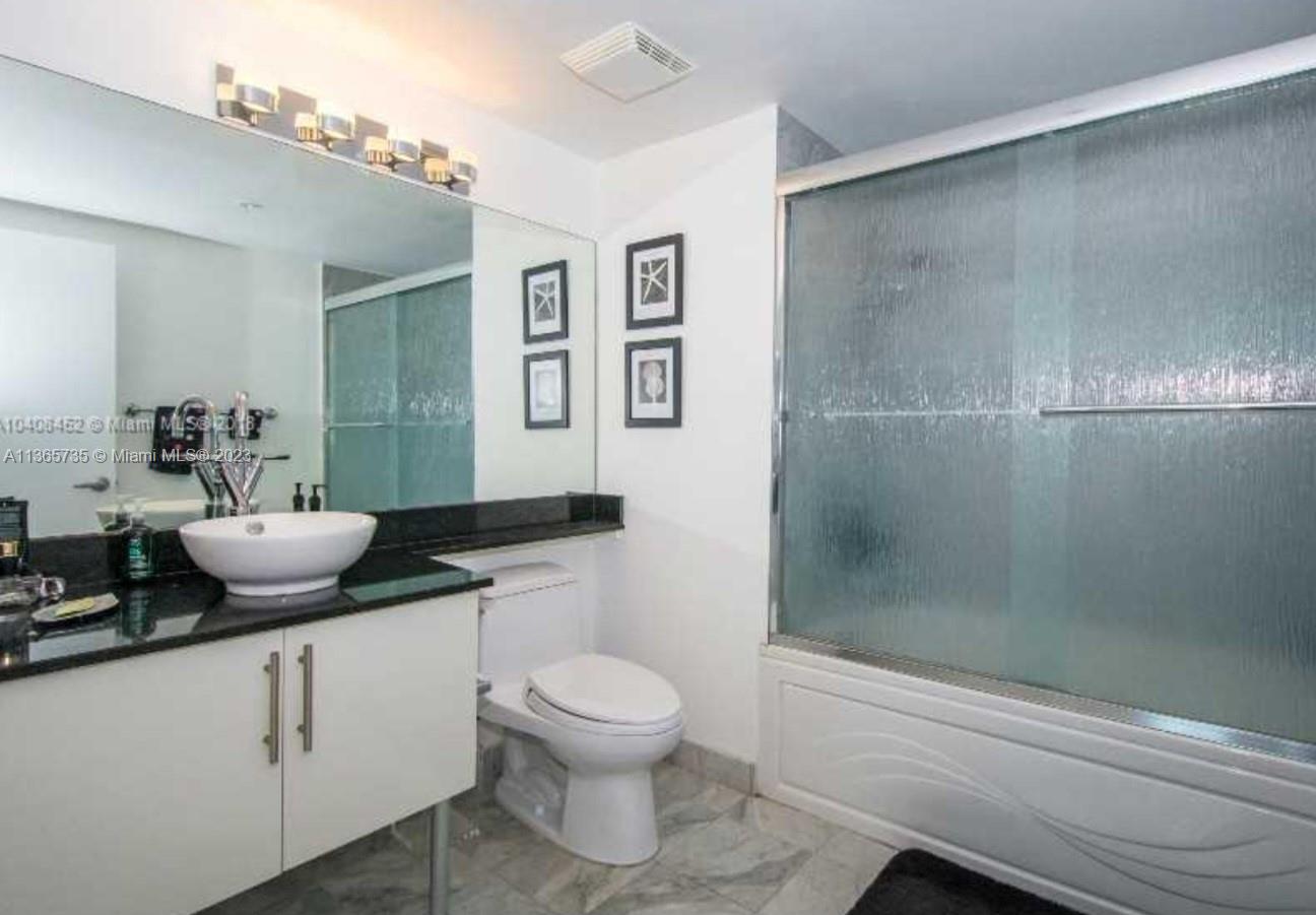 31 Southeast 5th Street, Unit 3309 Miami, FL 33131 - Photo 5 of 15 a bathroom with a granite countertop sink a toilet and shower