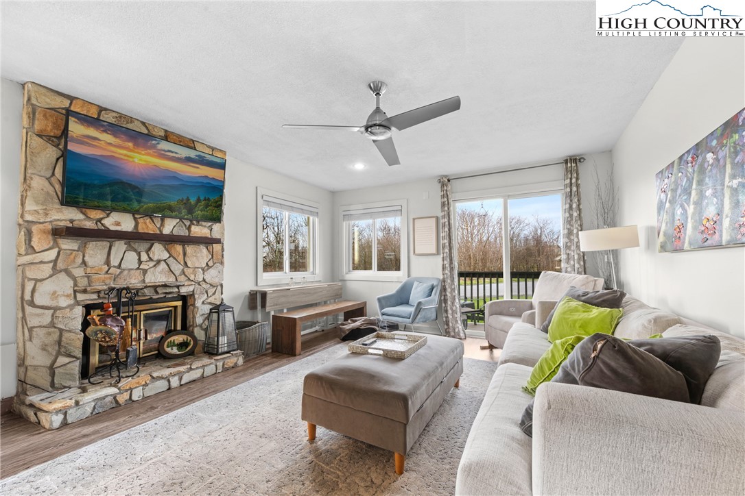 a living room with furniture a flat screen tv and a fireplace