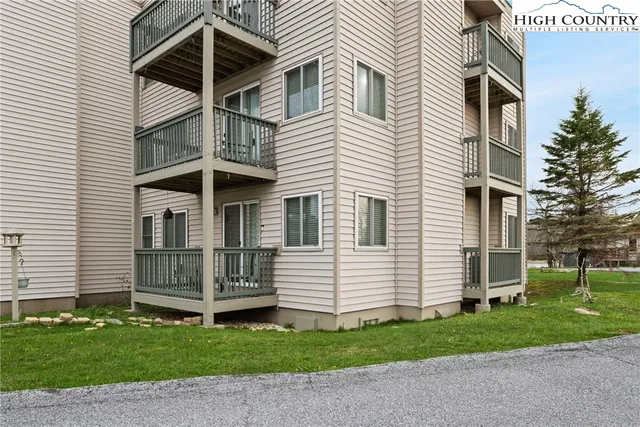 a view of a house with wooden deck and furniture